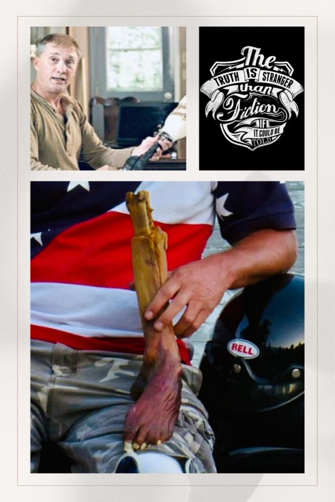 Man in a beige shirt sits indoors, looking toward the camera.